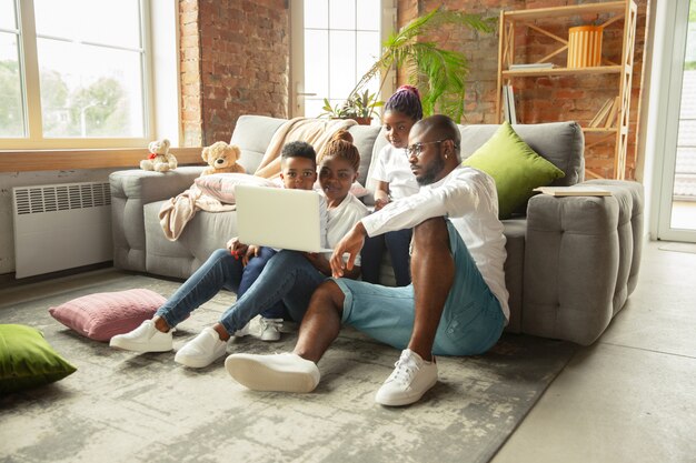 Young and cheerful family during quarantine, insulation spending time together at home.