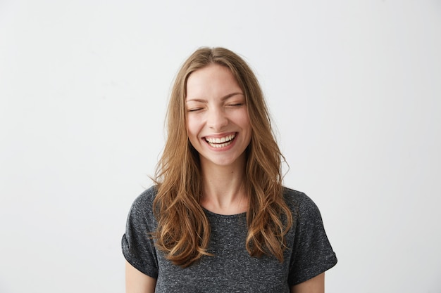 Young cheerful happy girl smiling laughing with closed eyes .