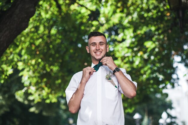 Young cheerful man posing in bow tie