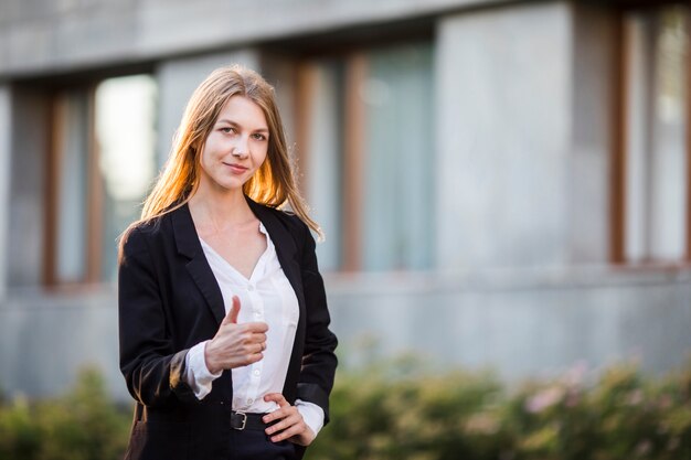 Young cheerful woman showing thumb up