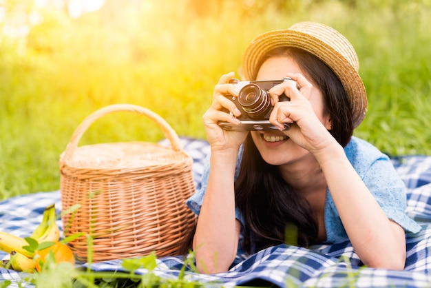 自然の中で写真を撮る若い陽気な女性