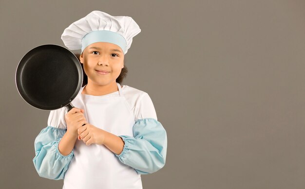 Young chef holding cooking pan