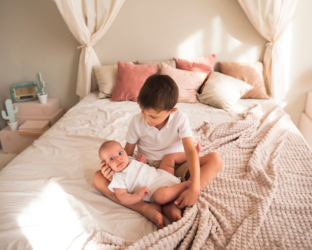 Young child hugging newborn baby