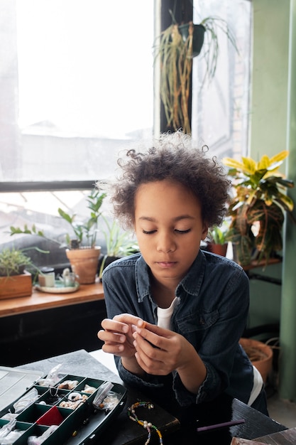 Foto gratuita bambino piccolo che fa progetti fai da te con materiali riciclati