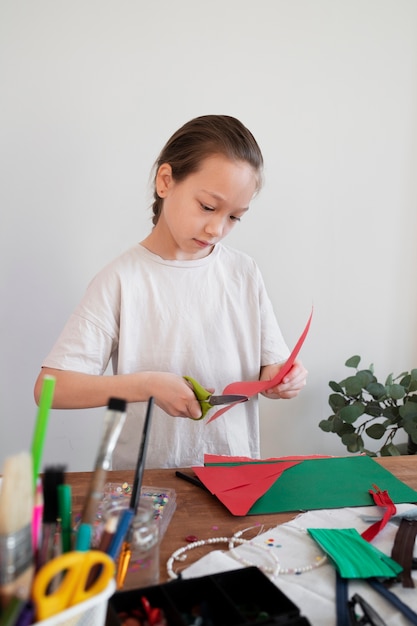 Маленький ребенок делает проект своими руками из переработанных материалов