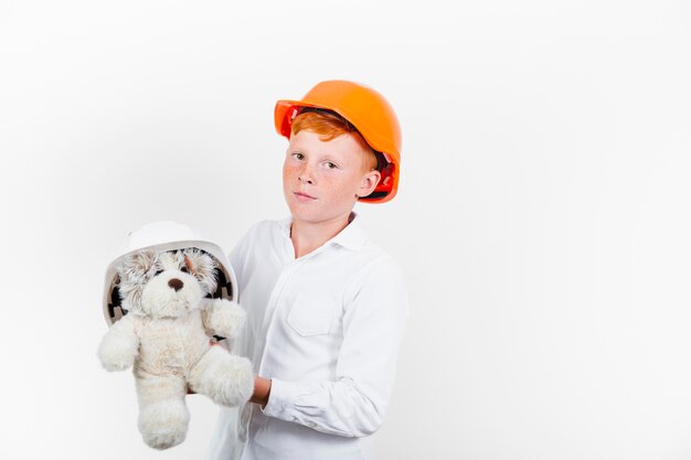 Young child with safety helmet and teddy bear