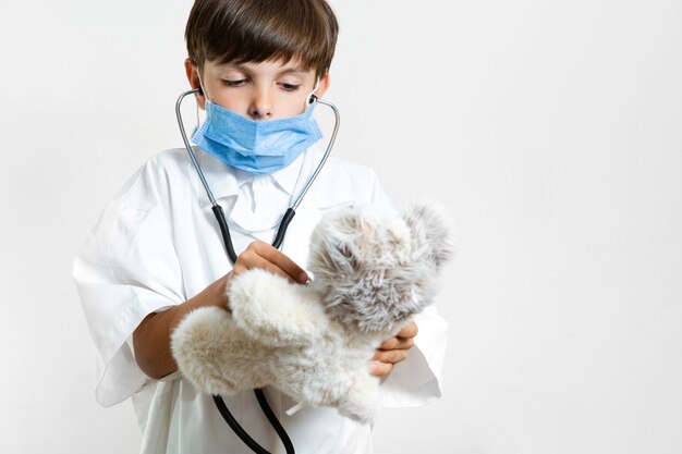 Young child with stethoscope and teddy bear