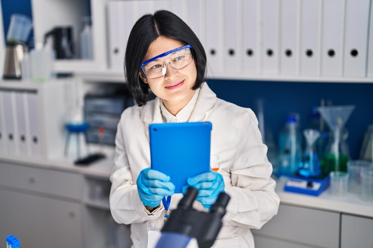 Free Photo young chinese woman scientist using touchpad working at laboratory