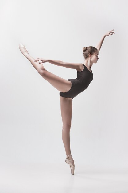 Young classical dancer dancing on white background. Ballerina project.