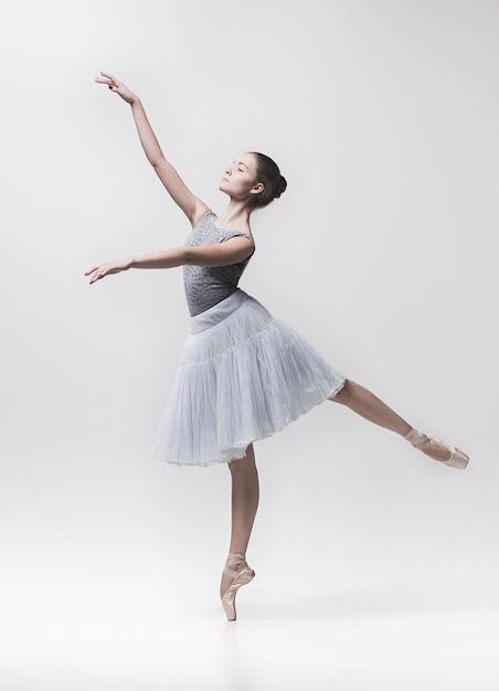 Young classical dancer dancing on white background. Ballerina project.