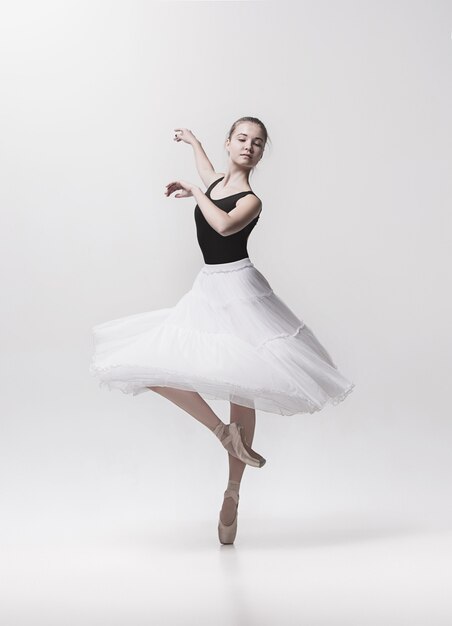 Young classical dancer dancing on white background. Ballerina project.