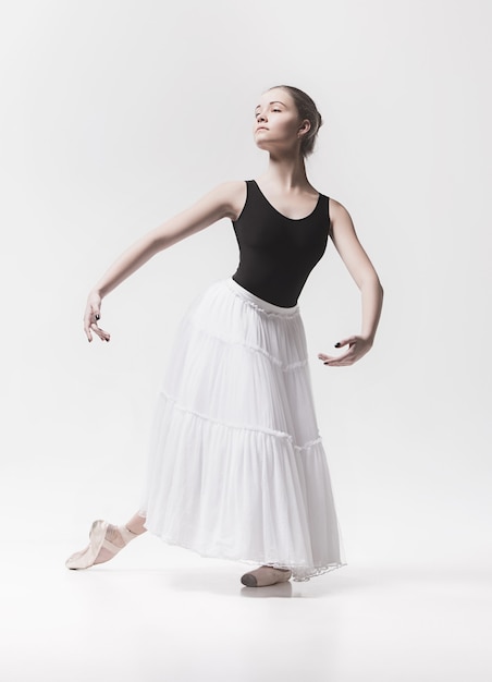 Young classical dancer dancing on white background. Ballerina project.