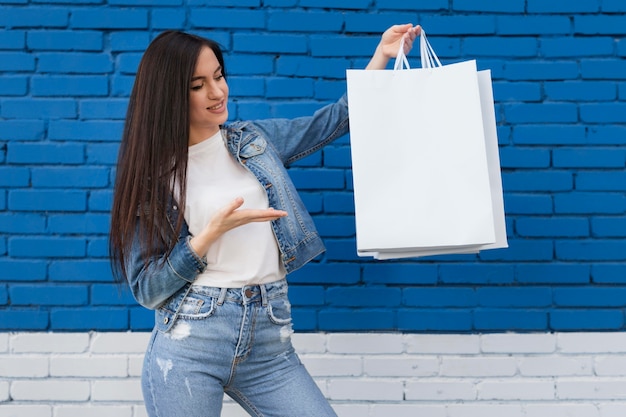 Foto gratuita giovane cliente che mostra la borsa bianca dello spazio della copia