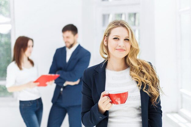 Young colleagues having coffee break, chatting in office