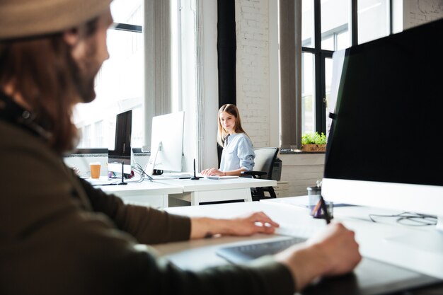 Young colleagues work in office using computers