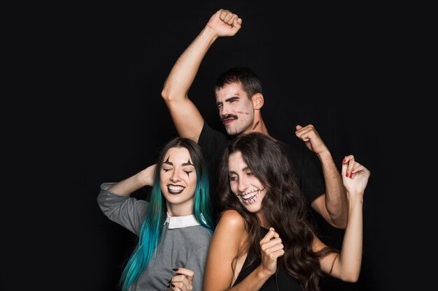 Young company dancing on Halloween party