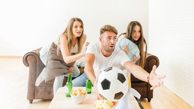 Молодая компания смотрит футбол на диване