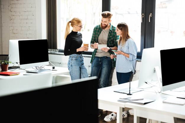 Young concentrated colleagues in office talking with each other