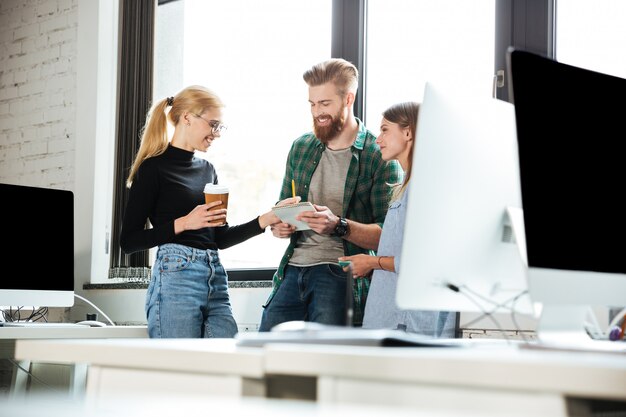 Young concentrated colleagues in office talking with each other
