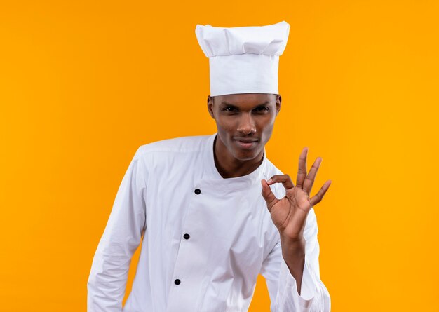 복사 공간 오렌지 배경에 고립 확인 요리사 유니폼 제스처에 젊은 자신감 아프리카 계 미국인 요리사