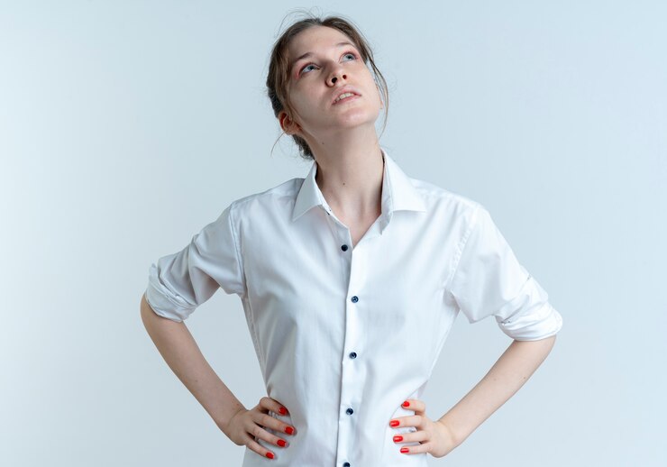 Free Photo young confident blonde russian girl puts hands on waist looking up isolated on white space with copy space