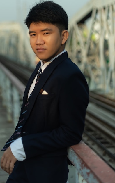 Free photo young confident business man leaning on a bridge railing