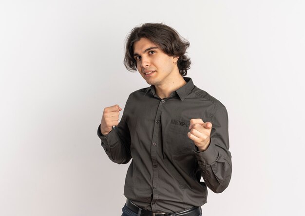 Young confident handsome caucasian man keeps fist and points at camera isolated on white background with copy space