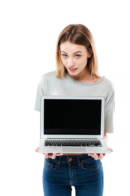 Young confident woman showing laptop computer with blank screen