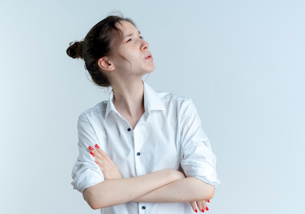 Free photo young confused blonde russian girl stands with crossed arms looking at side