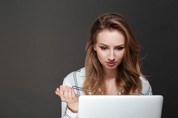 Young confused lady using laptop