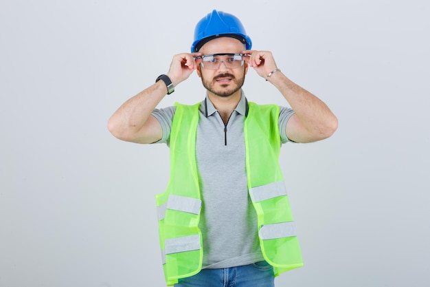 Young construction worker in a safety helmet and glasses