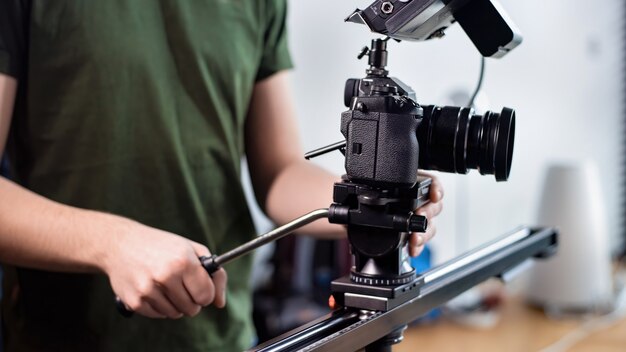 Young content creator man filming with camera on slider, professional rig