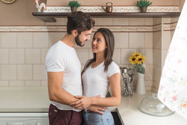 Young coule looking at each other in kitchen