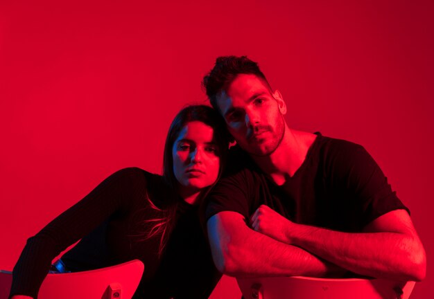 Young couple in black sitting on chairs 