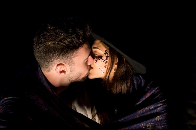 Young couple in blanket kissing 