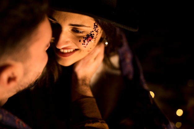 Free photo young couple in blanket sitting in darkness