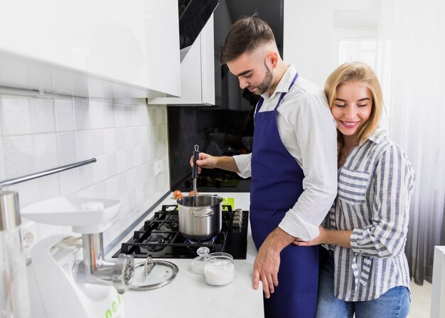 Young couple boiling water in pot
