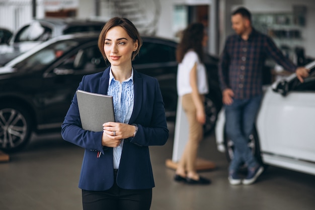 Free photo young couple byuing a car in a car showroom