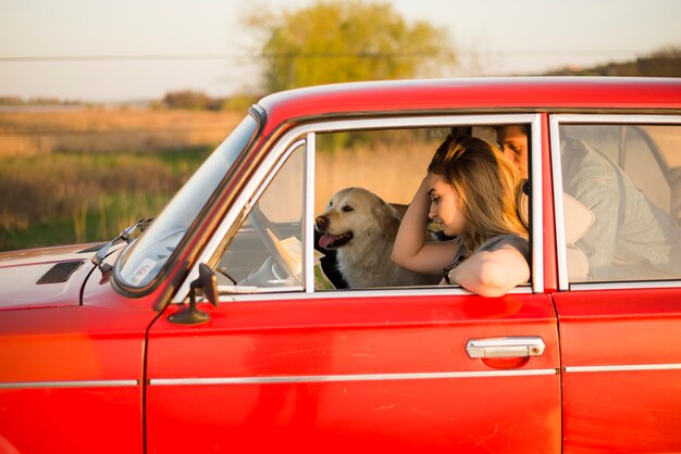 犬と一緒に車の中で若いカップル