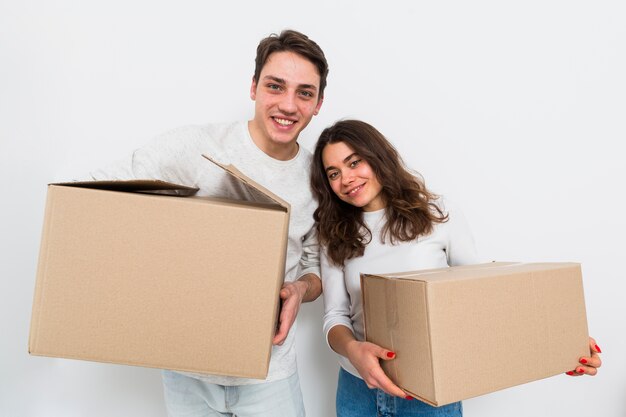 Young couple carrying cardboard boxes in hand isolated on white background