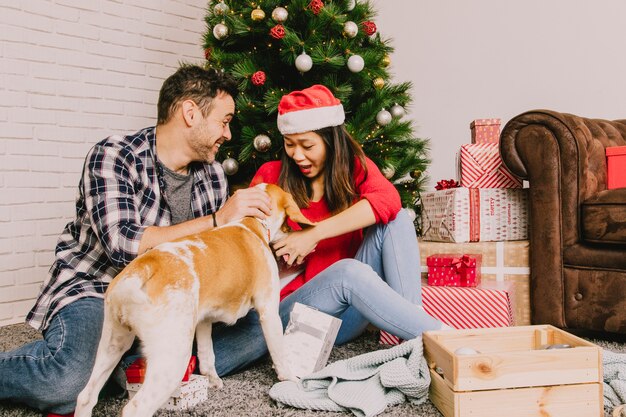 犬と一緒にクリスマスを祝う若いカップル