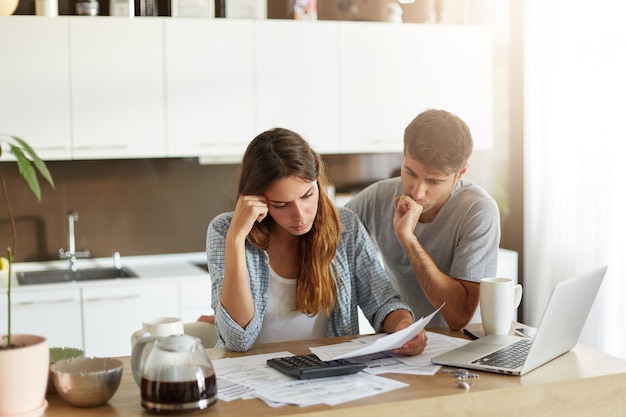 Foto gratuita giovani coppie che controllano il loro bilancio familiare