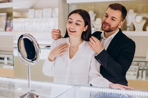Молодая пара выбирает ожерелье в ювелирном магазине