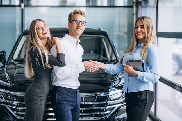 Young couple choosing a car in a car show room