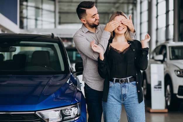 Young couple choosing a car in a car show room