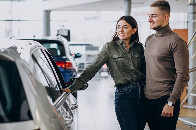 Young Couple Choosing A Car In A Car Show Room