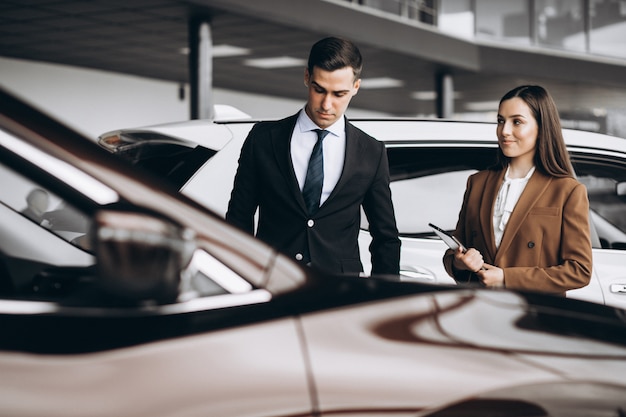 Young Couple Choosing A Car In A Car Show Room