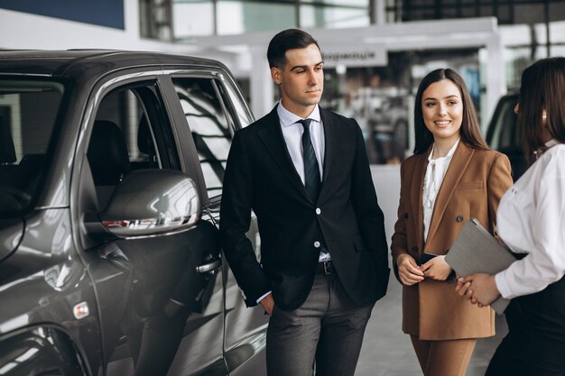 Young couple choosing a car in a car showroom