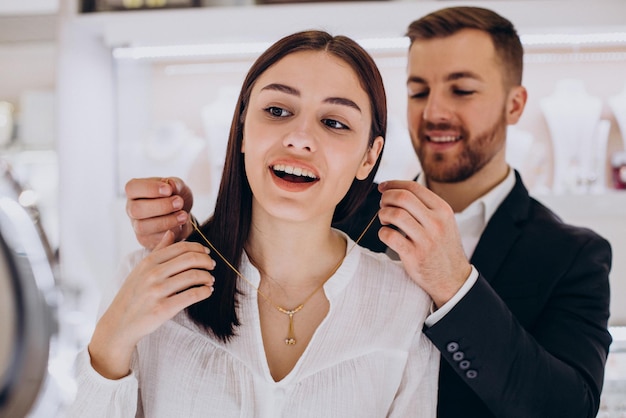 Free photo young couple choosing a necklace at jewelry store