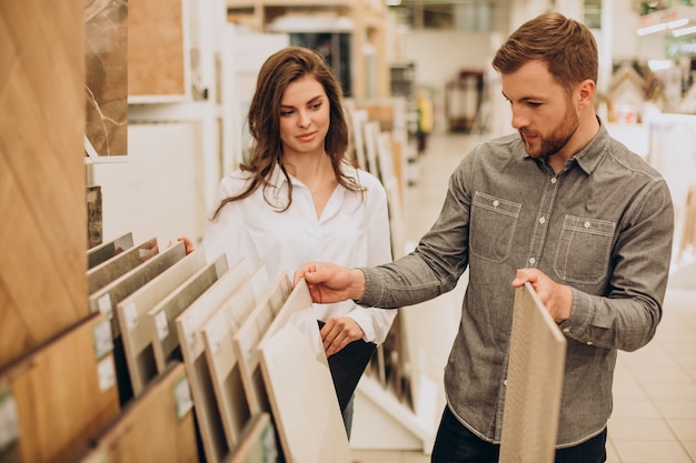 Free photo young couple choosing tiles at building market